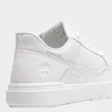 Championes Timberland modelo Allston, color blanco, estilo casual de caña baja con cordones. Presentan paneles superpuestos y perforaciones decorativas en el lateral. El logo de Timberland está grabado en el talón y en la lengüeta.