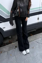 Pantalón de corte oxford en color negro, con diseño de tiro medio y pernera amplia desde la rodilla hacia abajo.