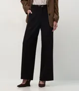 Pantalón de sastrería corte wide leg, color negro, con pliegues delanteros, bolsillos traseros embutidos y cinturón fino incluido.
