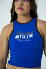 Musculosa corta azul con cuello y sisas con ribete marrón, de algodón elastizado y corte ajustado. Estampado frontal con texto "Hermod ART IS YOU".
