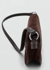 Bolso de hombro tipo baguette confeccionado en piel de serraje color marrón oscuro. Presenta un diseño rectangular con cierre de solapa y detalle metálico frontal. Incluye forro interior y bolsillo interno.