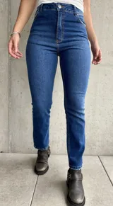 Jean de calce recto con lycra, color azul medio, con bolsillos delanteros y traseros.