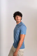 Remera de cuello redondo y manga corta en color azul, con un pequeño bordado de un pingüino esquiando en el pecho.