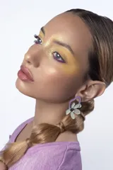 Par de aros colgantes con forma de flor color celeste y centro plateado, unidos a un aro irregular color lila.