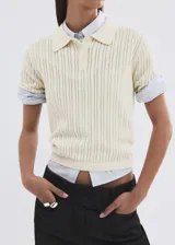 Chaleco de punto fino 100% algodón color amarillo pastel, con diseño calado, cuello polo, manga corta y cierre frontal con tres botones.