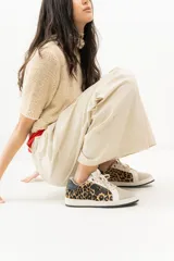 Championes de cuero color blanco con detalle de corona en animal print y talón verde. Cuentan con suela de caucho, lengüeta de gamuza y forro textil, con cierre mediante cordones al tono.