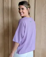 Remera de tejido de punto color lila, con escote en V y mangas cortas.