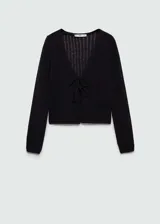 Cardigan de punto crochet color negro, con cuello en pico y cierre frontal mediante lazos. Presenta diseño corto de manga larga y textura calada.