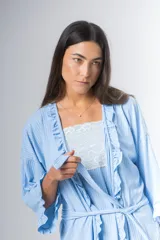 Bata kimono gris claro de algodón con volados en mangas y ruedo. Tiene mangas al codo y lazo de algodón para ajustar en la cintura.