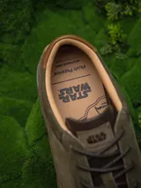 Championes de edición limitada inspirados en Star Wars, color verde oliva con detalles en marrón. Presentan una combinación de cuero y descarne, con el rostro de Yoda grabado en el lateral y el logo de Star Wars en la lengüeta.
