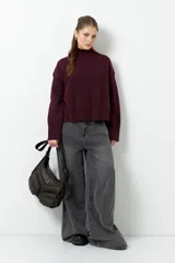 Polera de cuello alto confeccionada en tejido de punto, con manga larga y costura central decorativa en el frente.