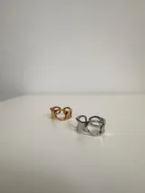 Anillo plateado con diseño irregular y aberturas circulares.