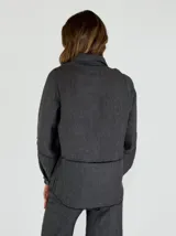 Chaqueta color amarillo de lino, con cuello camisero, cierre frontal con botones, mangas largas con puños abotonados y dos bolsillos de parche en el pecho.