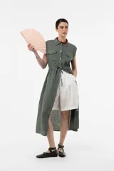 Vestido camisero midi sin mangas color verde militar, confeccionado en lino, con botones frontales, bolsillos en el pecho y cintura ajustable con cordón.