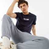 Camiseta azul marino de manga corta con estampado frontal de la frase 'Cape Town South Africa' en letras blancas. Corte clásico.