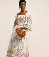 Vestido evasê midi confeccionado en viscolino, con mangas amplias, escote cuadrado en el busto y en la espalda, recorte en la cintura, lastex en la espalda y estampa de arabescos con estilo étnico en el tronco, mangas y en la bajo.