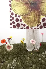 Pañuelo cuadrado de seda con estampado de lunares bordó sobre fondo beige y una gran ilustración central de una flor en tonos amarillos y marrones.