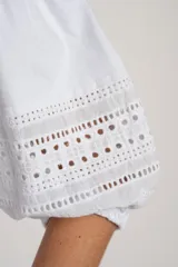 Remera negra de algodón con mangas tres cuartos abullonadas y detalle de bordado calado tipo ojal en la zona del antebrazo.