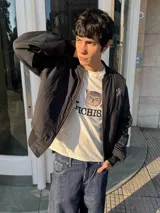 Campera bomber negra con cuello, puños y cintura acanalados. Presenta cierre frontal y bolsillos laterales. En la espalda tiene bordada la palabra "Bestia" en letras góticas blancas.