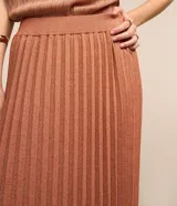 Pollera midi recta color ladrillo, de viscosa plisada con hilo metalizado y elástico en la cintura.