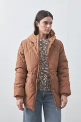 Campera puffer negra con diseño acolchado, capucha integrada y cierre frontal con botones a presión. Presenta puños elásticos y costuras decorativas en el frente.