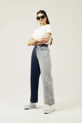 Pantalón de jean de pierna ancha con diseño color block: una pierna azul oscuro y otra gris claro.