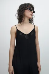 Maxi vestido negro de breteles finos con escote en V y detalle de encaje en el busto.