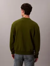 Buzo de cuello redondo Calvin Klein confeccionado en algodón regenerado de color verde militar, con interior de tejido terry, puños y cuello con punto canalé, y un pequeño parche con el monograma de la marca en el pecho.
