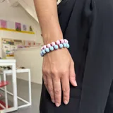 Pulsera elástica con doble hilera de cuentas de madera redondas, una hilera en color celeste y otra en color rosa.