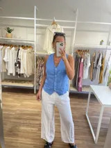 Chaleco de lino 100% color celeste, con escote en V y cierre frontal de botones.