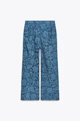 Pantalón cropped de encaje azul con tiro alto, bolsillos delanteros, pernera recta y corta, forro interior corto y cierre frontal con cremallera, botón interior y gancho.
