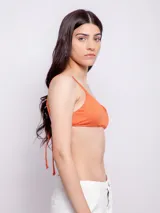 Top de bikini color naranja con textura animal print, breteles finos regulables, gancho en espalda, forro interior y copas desmontables.