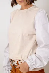 Remera de algodón color azul marino, con cuello redondo fruncido y mangas largas abullonadas con puños elásticos.