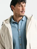 Camisa de denim de algodón con cuello clásico, cierre frontal con botones, bolsillo superior de parche y mangas largas con puños abotonados.
