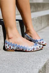 Bailarinas con estampado animal print, ribete superior en zig zag color lila y suela plana.