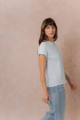 Remera básica color celeste, de corte relajado, cuello redondo y mangas cortas con hombro caído y dobladillo.