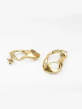 Pendientes de diseño irregular con textura martillada y acabado dorado. Presentan una forma orgánica y cierre de broche.
