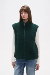 Chaleco sin mangas de textura peluche (teddy) color crema, con cuello alto y cierre frontal de cremallera.