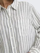 Camisa de manga larga con cuello clásico y bolsillo frontal, confeccionada en tejido de lino y viscosa con rayas verticales finas grises sobre fondo blanco.