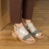 Sandalias bajas de cuero vacuno color beige, con tiras cruzadas en el empeine y ajuste con hebilla lateral.