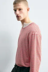 Camiseta de manga larga con ajuste relajado, cuello redondo y estampado de rayas horizontales en color rojo y blanco.