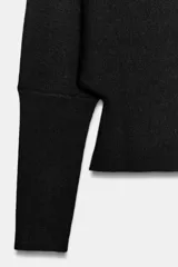 Jersey de punto color mostaza con escote en pico y manga larga con puños ajustados.