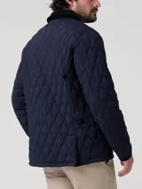 Campera acolchada de estilo inglés con diseño de rombos, cuello camisero en contraste y cierre frontal con broches a presión. Cuenta con bolsillos laterales y un ajuste regular.