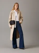 Bandolera negra de cuero sintético con correa de cadena plateada y logo CK plateado en el frente.