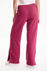 Pantalón deportivo negro de corte wide leg, sin frisa, con ribete blanco en los laterales y aberturas con botones en los tobillos.