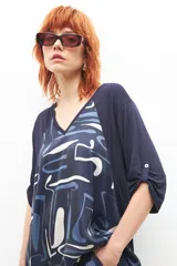 Vestido azul marino con estampado abstracto en blanco y celeste, escote en V y mangas cortas.