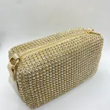 Bolso de mano rectangular color dorado, cubierto de strass. Tiene asa corta de ecocuero y asa larga de cadena desmontable.
