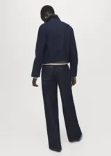 Chaqueta de algodón estilo denim en color azul oscuro, con cuello camisero, bolsillos de parche con solapa en el pecho y cierre frontal con botones.
