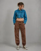Pantalón tipo cargo de corte holgado en color marrón con efecto lavado oxidado. Presenta bolsillos laterales tipo cargo, cintura con trabillas y puños elásticos en los tobillos.