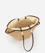 Bolso de playa tipo tote de paja natural con asas de cuero sintético marrón, forro interior y bolsillo interno.